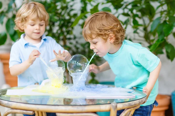 Zwei Zwillingsjungen experimentieren mit bunten Blasen — Stockfoto