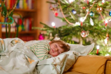Noel ağacının altında uyuyan küçük şirin çocuk çocuk