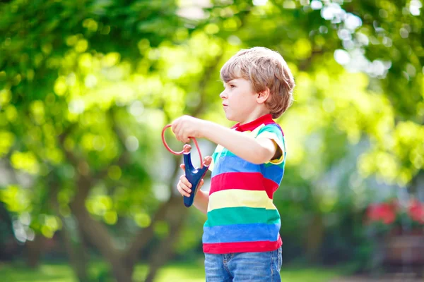 Little kid boy shooting wooden slingshot — Stock Photo, Image