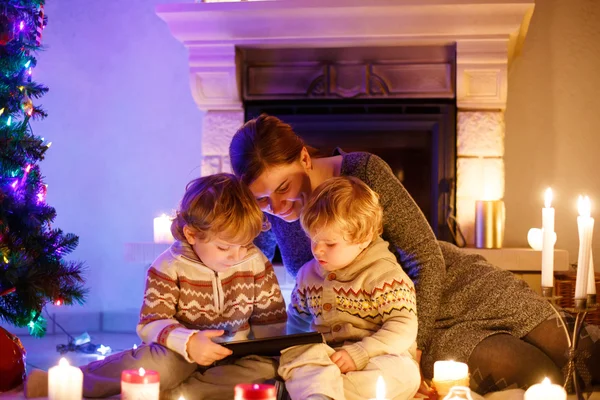 若い母親と C に暖炉のそばに座って彼の小さな子供たち — ストック写真