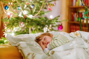 Noel ağacının altında uyuyan küçük şirin çocuk çocuk