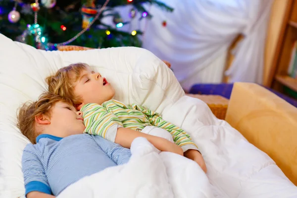 Zwei kleine blonde Geschwister schlafen an Weihnachten im Bett — Stockfoto