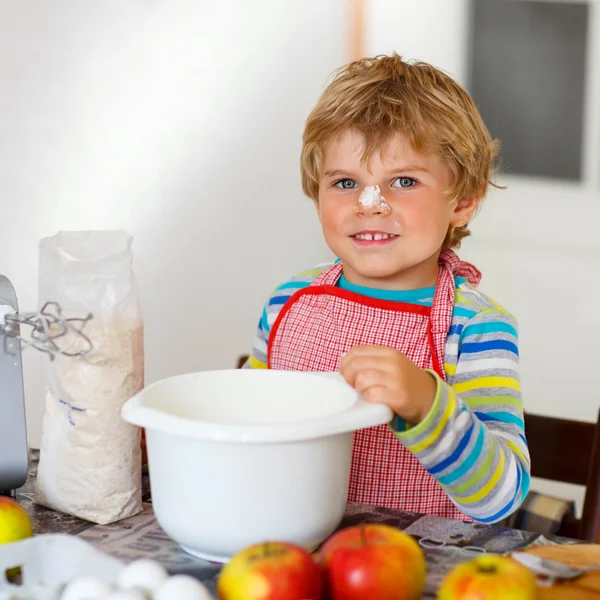 Divertido chico rubio hornear pastel de manzana en el interior —  Fotos de Stock