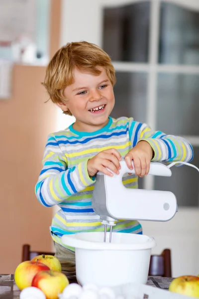 Lustige blonde Kind Junge backt Apfelkuchen drinnen — Stockfoto