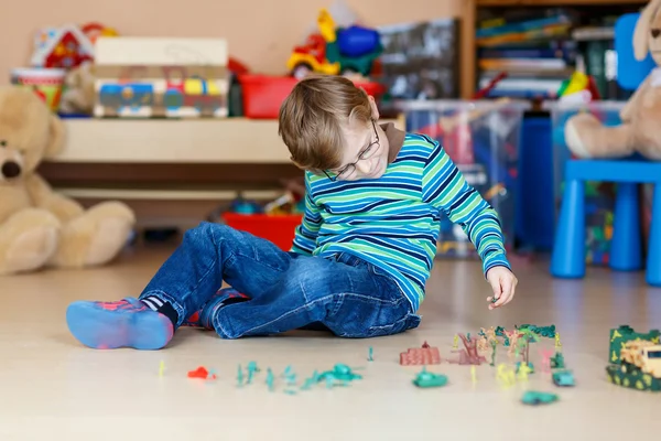 子供の保育園で室内でおもちゃの兵隊と遊ぶ少年 — ストック写真