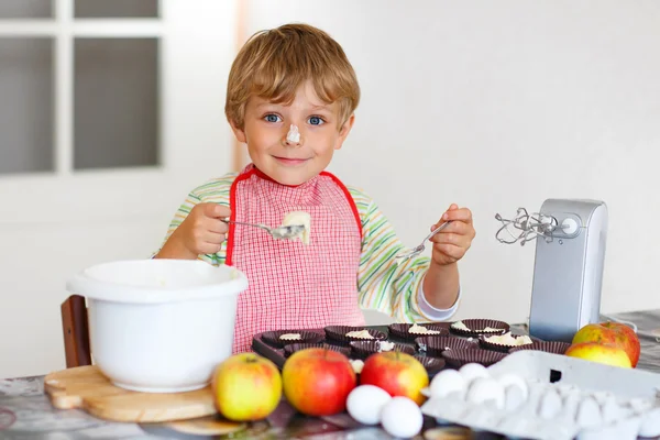 Engraçado menino loiro cozinhando bolo de maçã dentro de casa — Fotografia de Stock