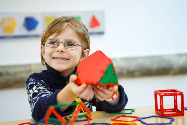 Malý chlapec dítě vytváření geometrických obrazců s plastovými bloky — Stock fotografie