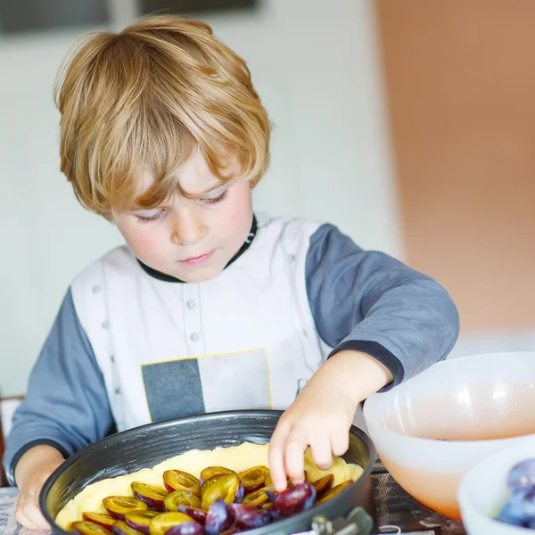 Adorable little boy helping and baking plum pie — Stock Photo, Image