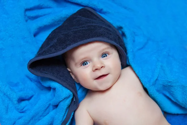 Menino menino pequeno contra a toalha de banho azul — Fotografia de Stock