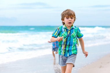 İki küçük okyanus plaj üzerinde çalışan çocuklar çocuk