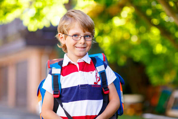 little kid boy with school satchel on first day to school