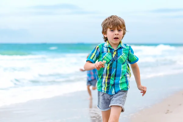 两个小孩子运行在海洋沙滩上的男孩 — 图库照片
