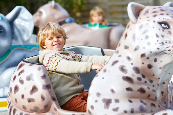 Little kid boy on carousel in amusement park — Stock Photo, Image