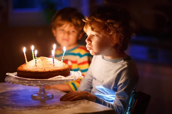 Little kid boy and brother blowing candles on birthday cake — Stock Photo, Image