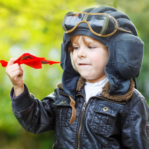 Dítě chlapec v pilotní přilba hraje s hračkou letadla — Stock fotografie