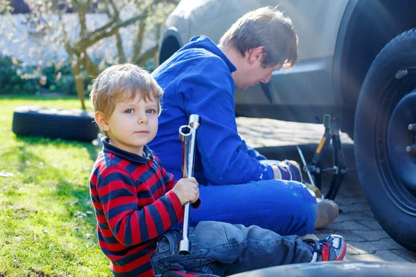 Little kid boy and his father changing wheel on car — Stock Photo, Image