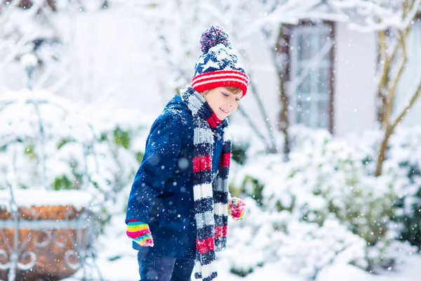 Szczęśliwy chłopiec bawiący się śniegiem w zimie — Zdjęcie stockowe