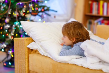 Noel ağacının altında uyuyan küçük şirin çocuk çocuk
