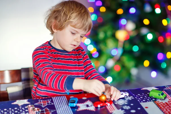 Little blond child playing with cars and toys at home — Stock Photo, Image