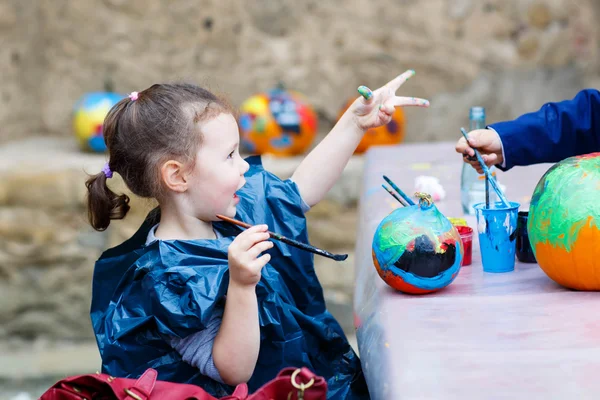 Niña pintando con colores en calabaza —  Fotos de Stock