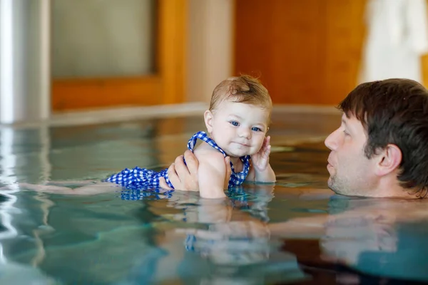 Feliz padre de mediana edad nadando con linda niña adorable en la piscina. — Foto de Stock