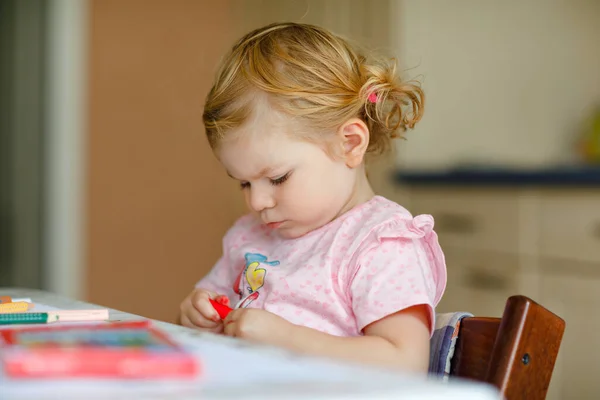 Kalemle resim yapmayı öğrenen sevimli bir bebek. Küçük çocuk renkli keçeli kalemlerle evde resim çiziyor. Evde ya da çocuk odasında renkler deneyen sağlıklı, mutlu bir kız.. — Stok fotoğraf