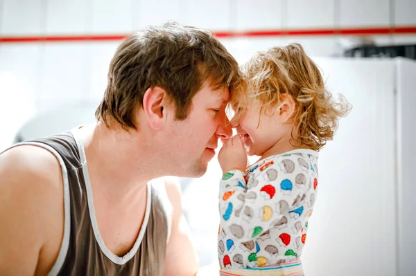 Padre che fa i capelli di una tenera bambina con l'asciugacapelli. Adorabile bambino sano con i capelli bagnati dopo aver fatto il bagno. Relazione familiare tra figlia e padre — Foto Stock