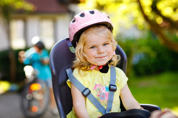 머리에 안전 헬멧을 쓰고 부모의 자전거 의자에 앉아 있는 어린 아기의 모습. 자전거를 타고 다니는 소년. 안전 과 아동 보호 개념. 가족 과 주말 활동 여행. — 스톡 사진