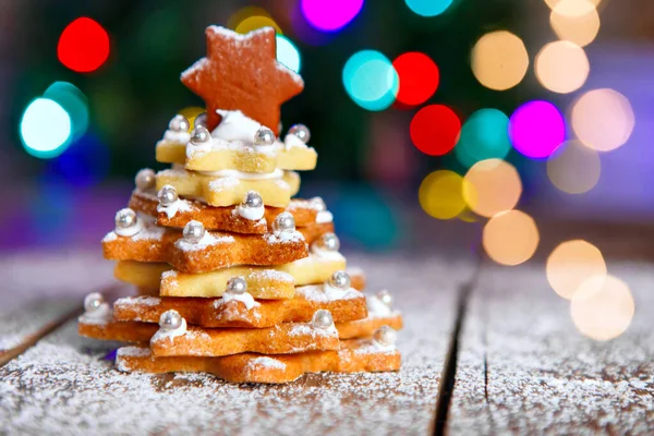 Home made baked Christmas gingerbread tree as a gift for family and friends on wooden background. With colorful lights from Christmas tree on background. With icing sugar gift for xmas — Stock Photo, Image
