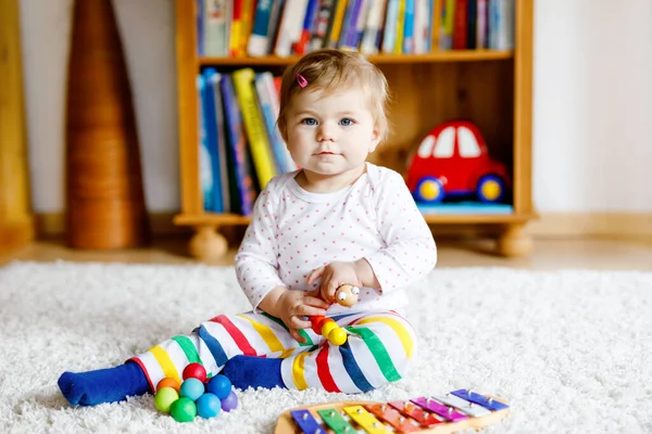 Adorable linda y hermosa niña jugando con juguetes educativos en casa o en la guardería. Feliz niño sano divirtiéndose con colorido juguete musical xilófono niño aprendiendo diferentes habilidades —  Fotos de Stock