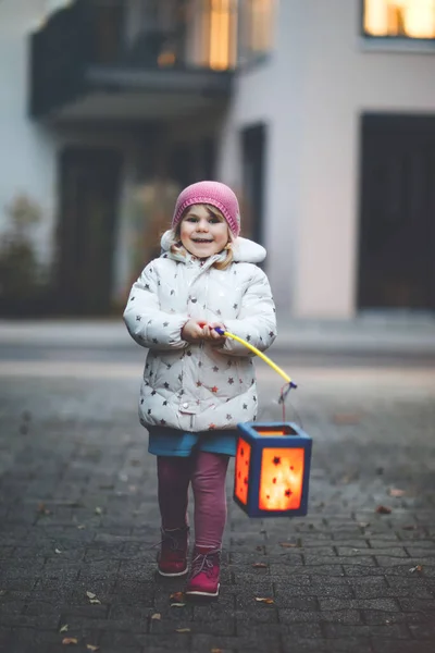 Little kid girl holding selfmade lanterns with candle for St. Martin procession. Healthy cute toddler child happy about children and family parade in kindergarten. German tradition Martinsumzug — Stock Photo, Image