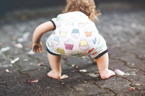 Carino adorabile bambina fare i primi passi all'aperto. Bambini sani e felici che imparano a camminare. Bella ragazza godendo giardino primaverile. — Foto Stock