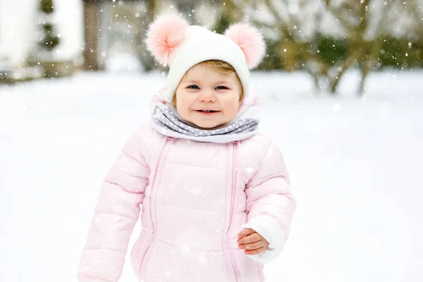 Schattig klein meisje dat 's winters de eerste stappen buiten zet. Leuke peuter leren lopen. — Stockfoto