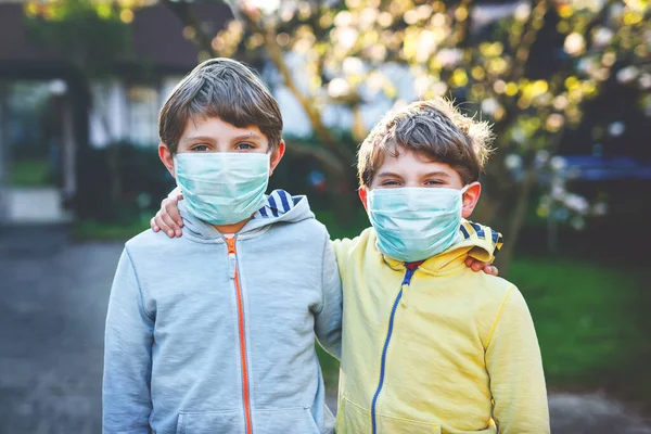 Due ragazzi mascherati come protezione contro la pandemia coronavirica. Bambini, fratelli e sorelle adorabili e migliori amici che usano attrezzature protettive come lotta contro covid 19. — Foto Stock