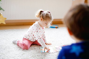 İki küçük çocuk, küçük tatlı kız ve okul çocuğu süslü Noel ağacında kağıt oynuyorlar. Mutlu sağlıklı kardeşler, erkek ve kız kardeşler birlikte eğleniyor. Aile Xmas kutlaması