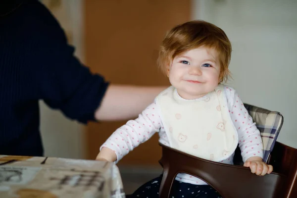 Pai alimentando bebê menina de purê de colher legumes e purê. comida, criança, alimentação e conceito de pessoas-bonito criança, filha e pai com colher sentado em cadeira alta e comer em casa. — Fotografia de Stock