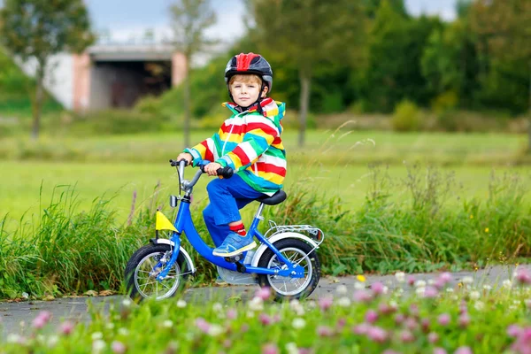 Kleiner netter Junge auf dem Fahrrad an einem Sommer- oder Autoparkttag. Gesundes fröhliches Kind hat Spaß beim Radfahren. — Stockfoto