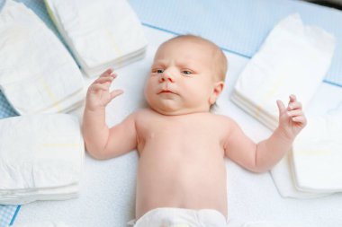 Bebek beziyle masayı değiştirirken sevimli bir bebek. Küçük tatlı bir kız ya da kameraya bakan bir oğlan. Kuru, sağlıklı vücut ve deri konsepti. Bebek odası..