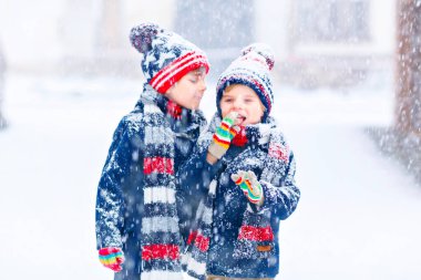 Mutlu çocuklar kışın karla eğleniyor.