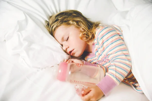 Söt liten småbarnstjej som sover i en stor säng med föräldrar. Bedårande barn drömmer i hotellsäng på familjesemester eller hemma. — Stockfoto