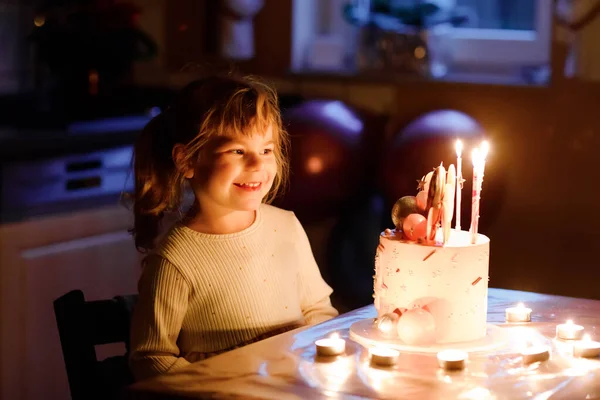 En förtjusande liten flicka som firar fyra år. Söta småbarn med hemmagjord prinsesstårta, inomhus. Glad frisk småbarn blåser 4 ljus på tårta — Stockfoto