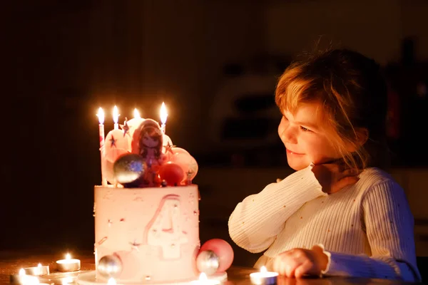 Entzückendes kleines Mädchen, das seinen vierten Geburtstag feiert. Nettes Kleinkind mit selbst gebackenem Prinzessinnenkuchen, drinnen. Glückliches gesundes Kleinkind bläst 4 Kerzen auf Kuchen — Stockfoto