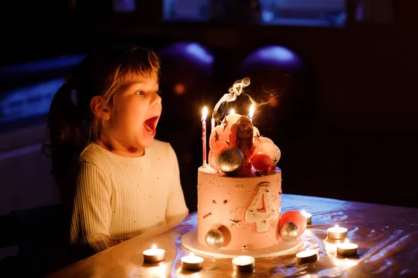 Adorable little toddler girl celebrating fourth birthday. Cute toddler child with homemade princess cake, indoor. Happy healthy toddler blowing 4 candles on cake — Stok fotoğraf