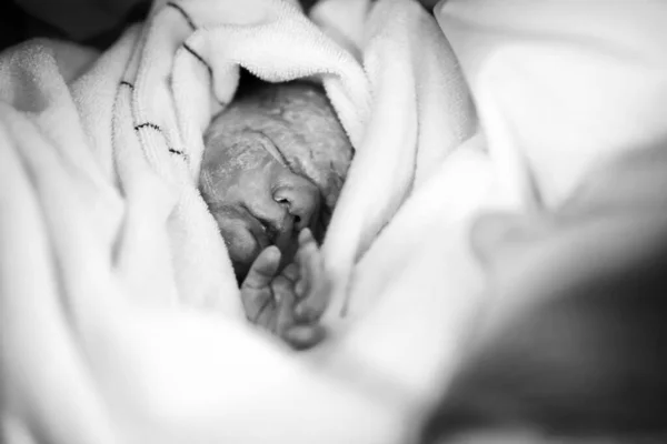 Bebê recém-nascido nascido via cesariana. Mãe procurando pela primeira vez na filha recém-nascida. Recém-nascido segundos e minutos após o nascimento. Mãe feliz chorando — Fotografia de Stock