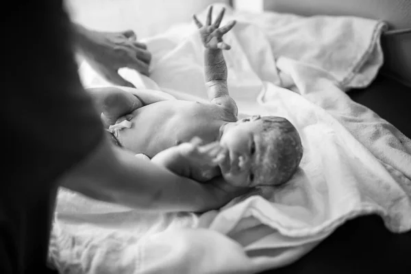 갓 태어난 아기가 태어나고 나서 몇 분 후에 태어납니다. 새로 태어난 아기와 의사 손을 잡고. 의료계에서는 어린이의 건강 상태와 반사 능력을 조사 한다. 새로운 삶, 시작, 건강 관리 — 스톡 사진