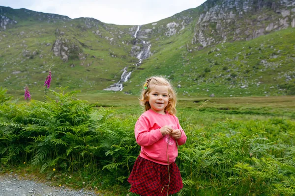 Nettes kleines, glückliches Kleinkind im Glenveagh Nationalpark in Irland. Lächelndes und lachendes Baby, das seinen Familienurlaub in der Natur genießt. Reisen mit kleinen Kindern — Stockfoto