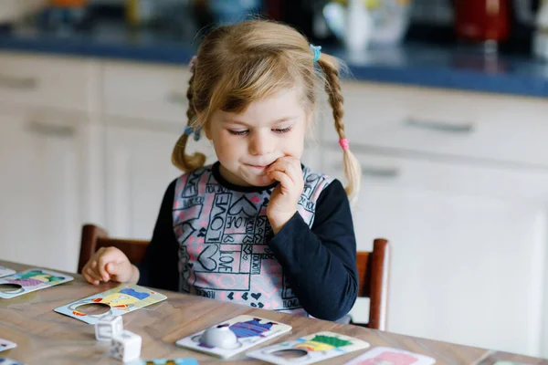 Imádnivaló aranyos kisbaba lány játszik kép kártya játék. Boldog egészséges gyermek edzés memória, gondolkodás. Kreatív beltéri szabadidő és nevelés a gyerek alatt pandémiás coronavirus covid karantén betegség — Stock Fotó