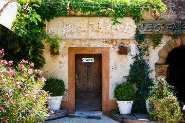 GORDES, FRANCE - 15 Temmuz 2014: Pastis gibi yemekleri ve içecekleri olan rahat bir kafe. Güney Fransa 'da tipik evleri olan Provencal caddesi, yaz günü Provence..