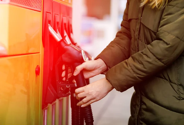 Primer plano de las manos de la mujer en la gasolinera de autoservicio, mantenga la boquilla de combustible y repostar el coche con gasolina, diesel, gas. Cierre de llenado automático con gasolina o bencina. Autoservicio bomba de gas — Foto de Stock