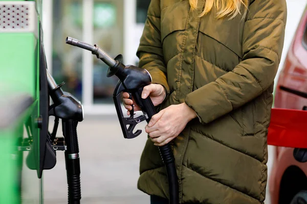 주유소에서 여성들의 손을 거의 잡고 연료 노즐을 쥐고 휘발유, 디젤, 가스로 차에 연료를 공급 했다. 자동차를 휘발유나 벤진으로 채우는 것을 마무리하는 것입니다. 자 가 용주 펌프 — 스톡 사진